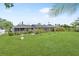 Expansive backyard featuring a screened-in lanai, lush landscaping, and a well-manicured lawn at 2242 Sunnyside Ln, Sarasota, FL 34239