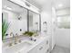 Bright bathroom showcasing a double vanity, sleek fixtures, and a tiled shower area at 2242 Sunnyside Ln, Sarasota, FL 34239