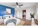 Stylish bedroom with a wood accent wall, bright blue accents, and a ceiling fan at 2242 Sunnyside Ln, Sarasota, FL 34239