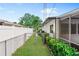 Fenced side yard with lush greenery and a gate, providing privacy and security at 2242 Sunnyside Ln, Sarasota, FL 34239
