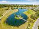 Aerial view of community pond with an island gazebo, connected by a charming bridge amidst lush greenery and pathways at 2320 Terra Ceia Bay Blvd # 305, Palmetto, FL 34221