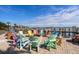 Inviting waterfront area with colorful Adirondack chairs arranged around a fire pit and with pier access at 2601 Gulf N Dr # B24, Bradenton Beach, FL 34217