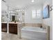 Bright bathroom featuring marble countertops, dark wood cabinetry, and a large bathtub at 3322 Bayou Rd, Longboat Key, FL 34228