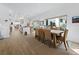 Open dining area with table seating eight, view to the kitchen, and light wood-look flooring at 3322 Bayou Rd, Longboat Key, FL 34228