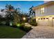 Paver driveway leads to an attached garage with an attractively landscaped yard at 3322 Bayou Rd, Longboat Key, FL 34228