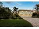 Expansive exterior showcases a well-manicured lawn and a convenient three-car garage at 3322 Bayou Rd, Longboat Key, FL 34228