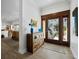 Bright foyer boasts wood-look flooring, rustic wood cabinet, and decorative glass front door leading to manicured yard at 3322 Bayou Rd, Longboat Key, FL 34228