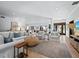 Open-concept living room featuring white sofas, light wood floors, and view of front door and dining area at 3322 Bayou Rd, Longboat Key, FL 34228