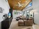 Comfortable living room featuring a leather sectional sofa, wood ceiling, and bright natural light at 3322 Bayou Rd, Longboat Key, FL 34228