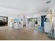 Spacious living room with light wood floors, recessed lighting, white sofas and chairs, and multiple windows at 3322 Bayou Rd, Longboat Key, FL 34228