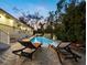 Relaxing pool features lounge chairs and a water feature surrounded by lush greenery and the home's exterior at 3322 Bayou Rd, Longboat Key, FL 34228