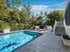 Stunning pool area with lounge chairs and a bar, set against a backdrop of lush tropical landscaping, perfect for relaxation at 3322 Bayou Rd, Longboat Key, FL 34228