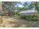 Lush backyard featuring mature trees and greenery surrounding an outbuilding at 3526 Austin St, Sarasota, FL 34231