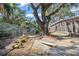 Backyard showcasing a chicken coop, greenhouse, and shaded area with mature trees at 3526 Austin St, Sarasota, FL 34231