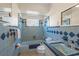 Full bathroom with blue tiles, a tub, a toilet, and a vanity at 3526 Austin St, Sarasota, FL 34231