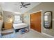 This bedroom boasts a ceiling fan, neutral walls, a comfortable queen bed, an accent chair, and a closet for ample storage at 3526 Austin St, Sarasota, FL 34231
