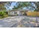 Charming single-story home featuring a beautifully landscaped front yard with mature trees and a brick-paved driveway at 3526 Austin St, Sarasota, FL 34231