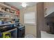 Well-organized laundry room with modern appliances, storage shelves, and a bright window at 3526 Austin St, Sarasota, FL 34231