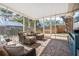 Cozy screened-in porch with outdoor seating, brick floors, and tranquil backyard setting at 3526 Austin St, Sarasota, FL 34231