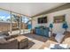 Inviting sunroom with brick flooring, comfortable seating, and a mounted TV for relaxation and entertainment at 3526 Austin St, Sarasota, FL 34231