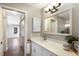 Well-lit bathroom with a long vanity with white cabinets, modern faucet, mirror and pendant light at 3606 Garden Lakes Clenet, Bradenton, FL 34203