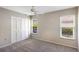 Bright bedroom with neutral walls, carpet, ceiling fan, and windows overlooking a lush green outdoor area at 3606 Garden Lakes Clenet, Bradenton, FL 34203