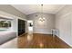 Open dining space with wood-look floors, a chandelier, and access to kitchen and living room at 3606 Garden Lakes Clenet, Bradenton, FL 34203