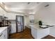 Modern kitchen featuring white cabinets, stainless steel appliances, and hardwood floors and a view into hall at 3606 Garden Lakes Clenet, Bradenton, FL 34203
