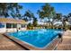 Community swimming pool with clear blue water, surrounded by mature trees and lounge chairs at 3606 Garden Lakes Clenet, Bradenton, FL 34203