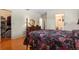Bedroom featuring hardwood floors, floral bedding, and views of the closet and bathroom at 3626 Medford Ln # 1537, Sarasota, FL 34232