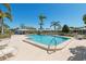 Community pool with a clear blue water, surrounded by lush palm trees, sun loungers, and well kept landscape at 3626 Medford Ln # 1537, Sarasota, FL 34232