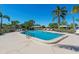 A large community pool with sun loungers around the perimeter surrounded by mature landscaping and palm trees at 3626 Medford Ln # 1537, Sarasota, FL 34232
