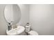 Stylish powder room featuring a modern oval mirror and pedestal sink at 3644 Pitch Ln, Sarasota, FL 34232