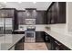 Elegant kitchen featuring dark wood cabinets, stainless steel appliances, and sleek countertops with subway tile backsplash at 3644 Pitch Ln, Sarasota, FL 34232