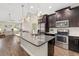 Modern kitchen with stainless steel appliances, dark cabinetry, a gray countertop, and decorative pendant lights at 3644 Pitch Ln, Sarasota, FL 34232