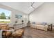 Cozy living room with wood-look floors, vaulted ceilings, and large windows for ample natural light at 3644 Pitch Ln, Sarasota, FL 34232