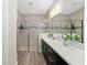 Elegant bathroom with double vanities, quartz countertop, tiled shower with glass enclosure, and wood-look floors at 3644 Pitch Ln, Sarasota, FL 34232