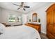 Bedroom showcases trey ceiling, stylish fan, wood floors, dresser, wardrobe, and a view to the ensuite bathroom at 3644 Pitch Ln, Sarasota, FL 34232