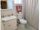 Well-lit bathroom with a vanity sink, toilet, and shower with a seashell-patterned curtain at 3660 Lake Bayshore Dr # K-321, Bradenton, FL 34205