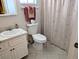 Well-lit bathroom features a vanity sink, toilet, and shower with a seashell-patterned curtain at 3660 Lake Bayshore Dr # K-321, Bradenton, FL 34205