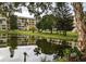 Scenic view of the building and pond with lush green landscaping and a variety of trees at 3660 Lake Bayshore Dr # K-321, Bradenton, FL 34205