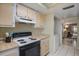 Cozy kitchen featuring light wood cabinets, and a view through to the living area at 3673 Longmeadow # 18, Sarasota, FL 34235