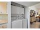 Functional laundry room with white washer and dryer, complemented by overhead cabinets at 3673 Longmeadow # 18, Sarasota, FL 34235