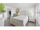 Comfortable bedroom featuring neutral decor, shuttered windows, and an open closet at 4390 Exeter Dr # 206, Longboat Key, FL 34228