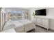 Bedroom featuring bright natural light, shuttered windows, and a modern TV at 4390 Exeter Dr # 206, Longboat Key, FL 34228
