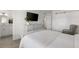 Bright bedroom with sliding barn door to closet and modern dresser and TV at 4390 Exeter Dr # 206, Longboat Key, FL 34228