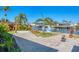 Beautifully landscaped backyard with a paved area, tropical plants, and serene water views, creating a private oasis at 4908 Arlington Rd, Palmetto, FL 34221