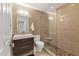 Elegant bathroom showcasing a glass-enclosed shower with stone floor, a floating vanity, and warm, neutral tiles at 4908 Arlington Rd, Palmetto, FL 34221