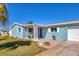Inviting single-story home with a charming entrance, well-maintained lawn, and lush landscaping at 4908 Arlington Rd, Palmetto, FL 34221