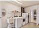 Functional laundry room with washer, dryer, utility sink, refrigerator, and ample storage space at 4908 Arlington Rd, Palmetto, FL 34221